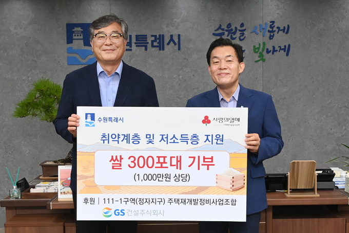 이재준 시장(오른쪽)과 김기태 현장소장이 쌀 전달식 후 기념촬영을 하고 있다.