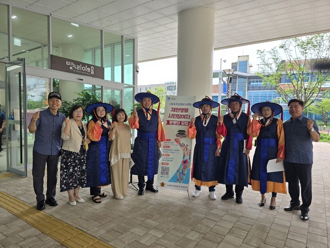 정찬해 수원화성문화제 공동위원장(왼쪽에서 5번째)와 위원들이 전통의상을 입고 홍보활동을 하고 있다.