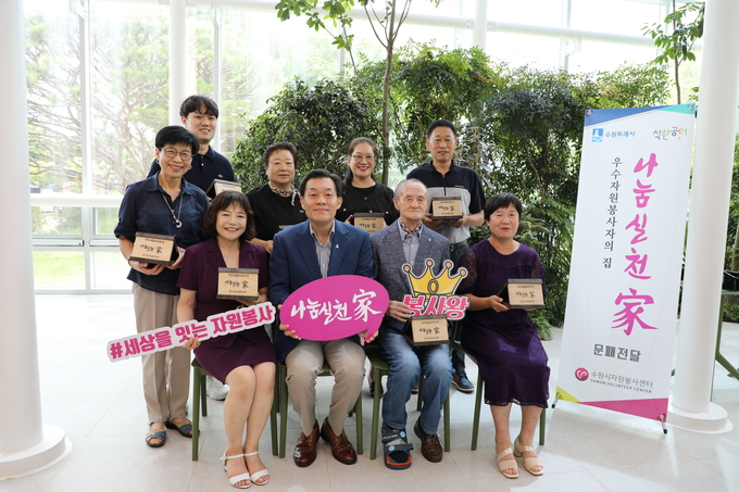 이재준(앞줄 왼쪽에서 2번째) 수원시장과 우수자원봉사자들이 25일 수원시청 새빛민원실에서 문패 전달식을 가진 뒤 기념촬영을 하고 있다.