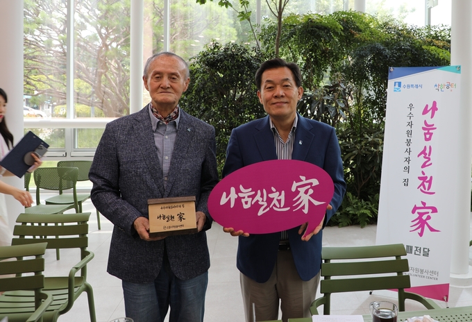 이재준(오른쪽) 수원시장이자 수원시자원봉사센터 이사장이 25일 수원시청 새빛민원실에서 90세 고령에도 봉사활동을 30년 이상해온 이강건 수원시금빛봉사회장과 기념촬영을 하고 있다.