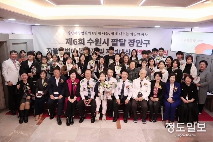 성영모 병원장을 비롯한 병원 임직원, 이상균 팔달구청장, 장학금 수상자들과 헤라건강학교 임원들이 함께 기념사진을 찍고 있다.