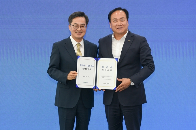 이권제 오산시장(오든쪽)이 11일 경기도청에서 열린 김기도지사-시장군수 정책련력위원희에 참석해 김동연<br>
지사에게 오산시 건의사항을 전담하고 기념람영을 하고 있다. 