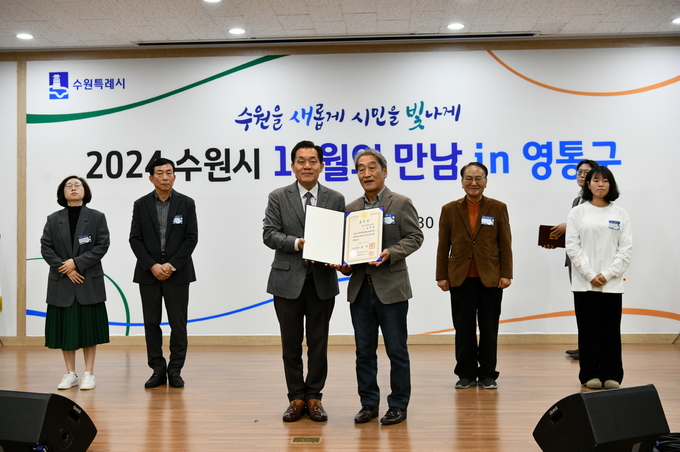 이재준 수원시장(왼쪽)과 송재등 전 매탄3동 주민자치회장이 표창장 전수 후 함께 하고 있다.