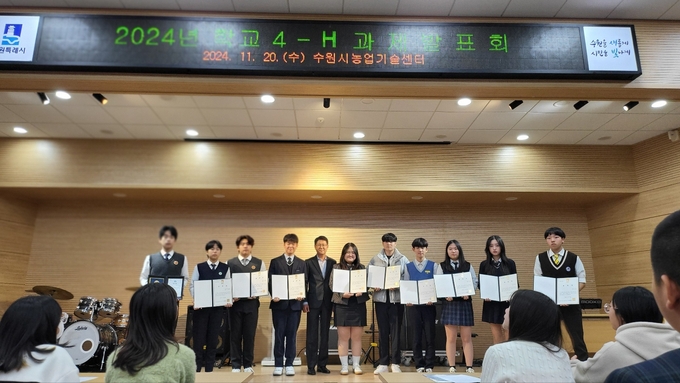 우수 4-H 학생들에게 표창을 수여하고, 단체사진을 찍고 있다.