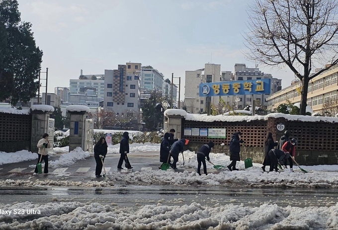 28일 오후의 이번 제설 작업은 동직원 및 통장 등 30여명이 여러 파트로 나눠서 진행을 했다. 영동중학교 앞 보행로 민관 제설작업 현장.