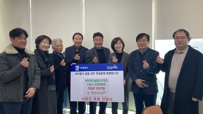 대한전문건설협회 경기도회 수원시 운영위원회 관계자들이 성금 전달 후 기념촬영을 하고 있다.