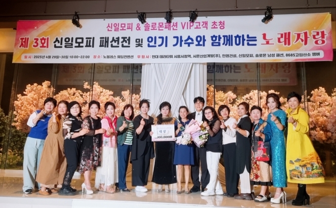 제3회 신일모피 패션전 및 인기가수와 함께하는 노래자랑 대상 수상한 안선미씨(오른쪽에서 8번째)를 축하해주는 엄민영회장(왼쪽에서 8번째)과 조항조가수(오른쪽애서 7번째)와 지인들이 함께 하고 있다