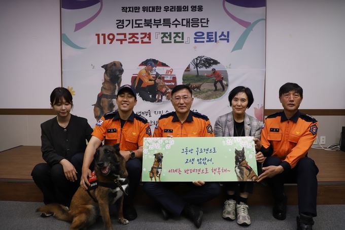 16일 남양주시 119구조견센터에서 열린 119구조견 ‘전진’의 은퇴행사에서 참석자들이 전진과 기념촬영을 하고 있다. = 사진 경기도