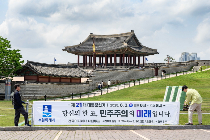 투표 참여를 독려하는 문구가 적힌 현수막을 설치하고 있다.
