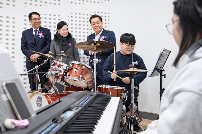 이재준 수원시장이 효동초등학교 청개구리 연못에서 악기를 연주하고 있는 청소년들을 바라보고 있다.