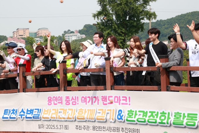 5월 31일 탄천수변길 반려견과 함께 걷기 & 환경정화 활동에 참석한 이상일 시장이 참가자들과 정화용 황토볼을 던지고 있다 사진=용인시