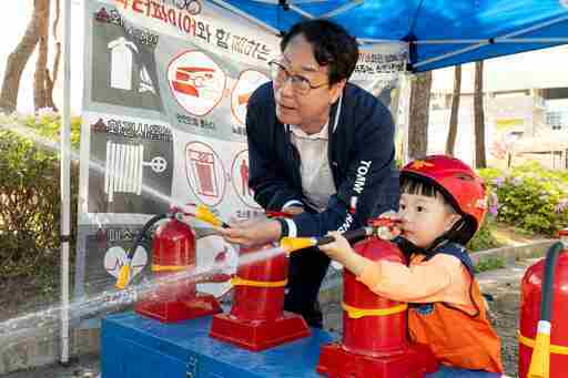 정명근 화성시장이 화성특례시 어린이날 영유아가족 어울림축제에서 어린이와 함께 소화기 사용 체험을 하고 있다.