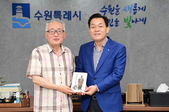 이재준 수원시장(오른쪽)과 박환 고려학술문화재단 이사장(왼쪽)이 평전을 들고 기념 촬영을 하고 있다.