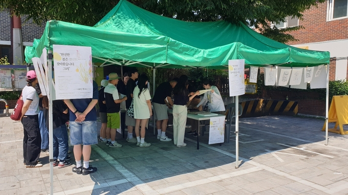 22일 오후 1시, 나혜석 문화예술제가 열리는 행궁동행정복지센터 앞에서 부스를 운영하고 있는 윤희경 작가의 '나혜석 판화 체험'에 시민들이 줄을 서며 체험을 기다리고 있다.<br>
