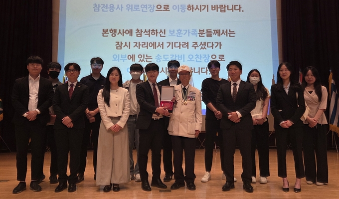 경기도가 주최한 6.25참천유공자회 기념 행사에서 수원청년위원회 회원들이 이구정 수원시지회장에게 감사패를 전달하고 기념사진을 찍고 있다. 