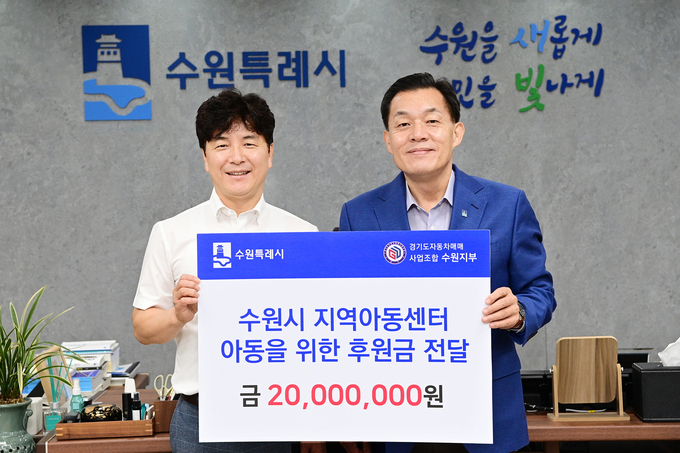 이재준 수원시장(오른쪽)과 경기도자동차매매사업조합 수원지부 김남윤 지부장이 전달식 후 함께하고 있다.