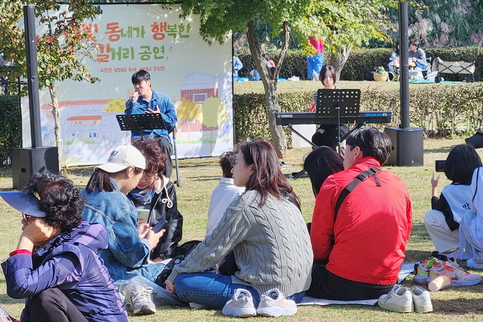 관광명소인 수원화성 용연에서 ‘새빛 동행버스킹’ 공연이 열리자 시민들이 자유롭게 감상하고 있다.
