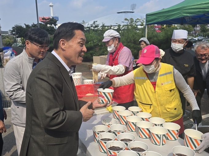 이재준 수원시장과 이동노동자들이 1일 오전 11시 수원종합운동장에서 수원시노사민정과 수원시자원봉사센터 협업으로 열린 ‘찾아가는 밥차’를 찾아 짜장면과 탕수육을 배식받고 있다.