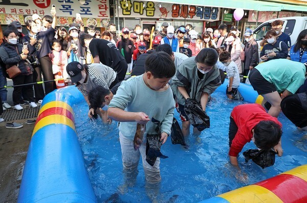 제10회 시흥월곶포구축제 중 맨손 고기잡이 체험에 참여 중인 시민들 [사진=시흥시