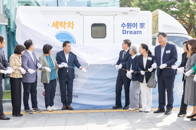 이재준(중앙 왼쪽) 수원특례시장과 장정희(중앙 왼쪽에서 두 번째) 수원특례시의회 기획경제위원장, 창성수(중앙 오른쪽) MG새마을금고 지역나눔재단 사무국장을 비롯해 자원봉사단체장들이 2일 오전 수원시청 본관 앞에서 찾아가는 세탁차 제막식 기념촬영을 하고 있다.