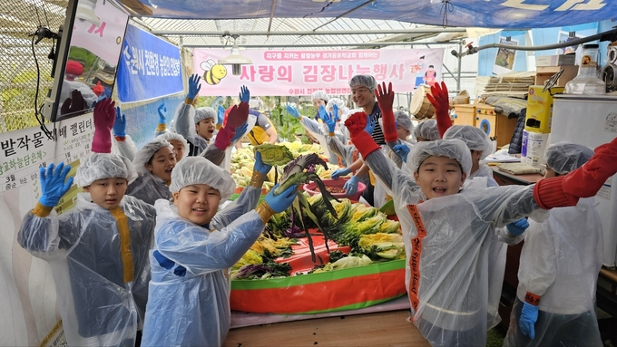 김장나눔 행사에 참가한 학생들이 활짝 웃고 있다.
