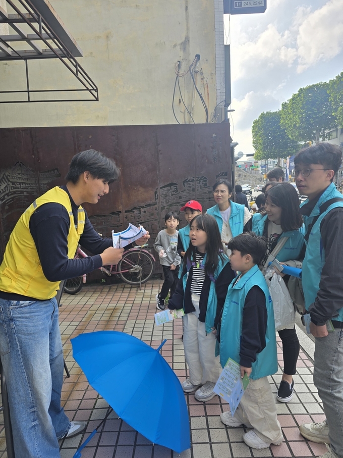 지난 25일 ‘수원화성 볼런투어’에 참여한 안성시가족봉사단이 김세환 집터 앞에서 자원봉사의 역사퀴즈를 듣고 있다.