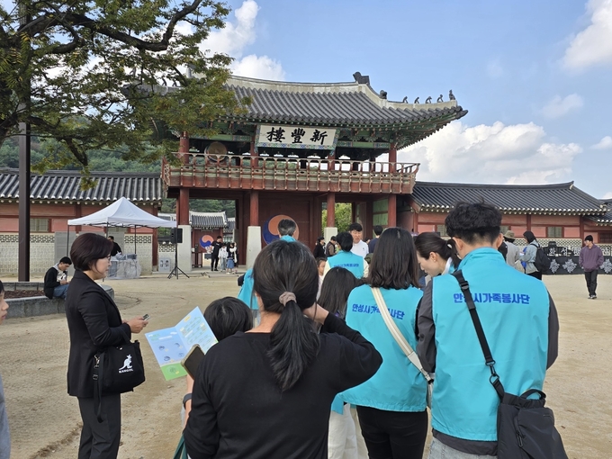 지난 25일 ‘수원화성 볼런투어’에 참여한 수원, 안성의 가족봉사단이 화성행궁 안으로 향하고 있다.