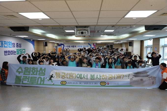 지난 25일 오전 ‘수원화성 볼런투어’에 참여한 수원, 안성, 의왕, 용인 등의 가족봉사단이 팔달구청 대회의실에서 교육을 받은 뒤 기념 촬영을 하고 있다.