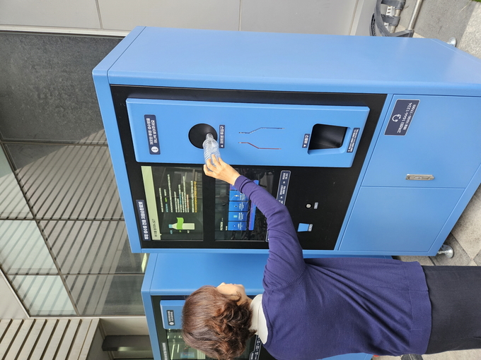 수원시 관계자가 투명페트병 무인회수기에 페트병을 투입하고 있다.