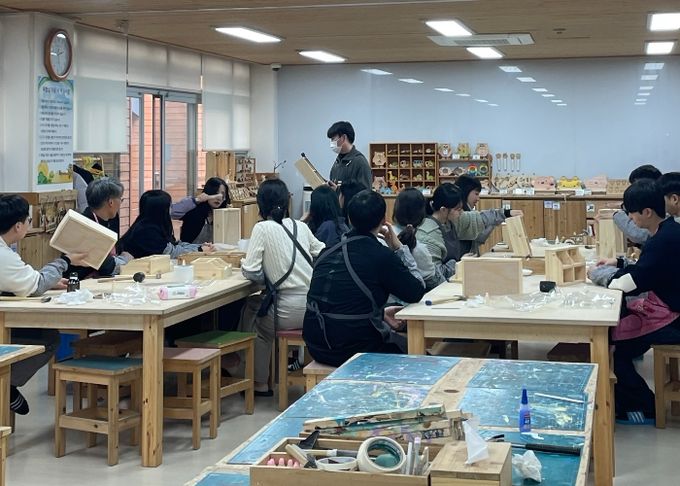 용인자연휴양양림 내 목재문화체험관에서 목공예 프로그럄에 참여하고 있는 교육생들의 모습