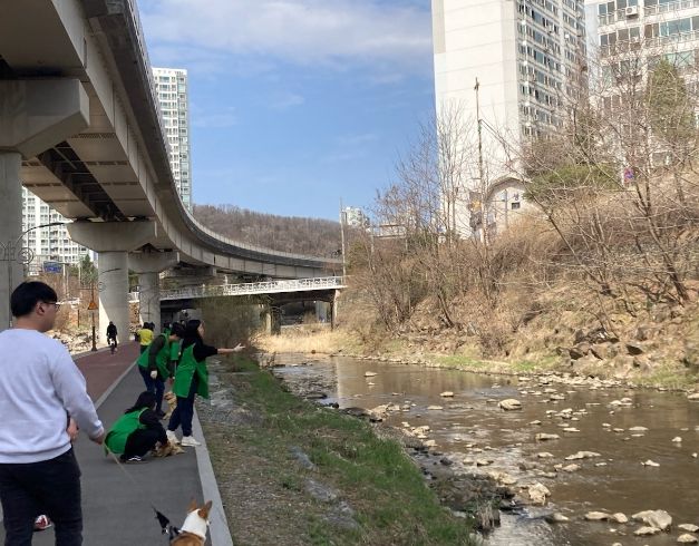 지난 24일 상하동 주민자치위원회가 상하천 수질개선을 위해 EM흙공 던지기 봉사활동을 열었다.