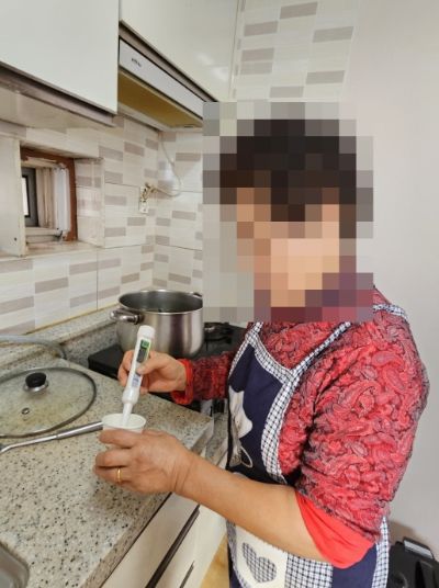 어르신이 음식의 염도를 재고 있다.
