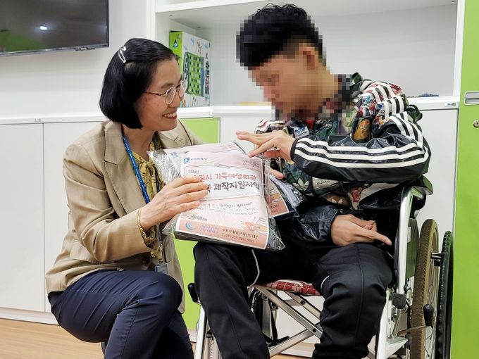 수원시가족여성회관이 오는 9월까지 ‘편의복 제작·지원 사업’을 추진하고 있는 가운데 한 장애인이 회관이 리폼·수선한 편의복을 전달받고 있다. (사진=수원도시공사 제공)