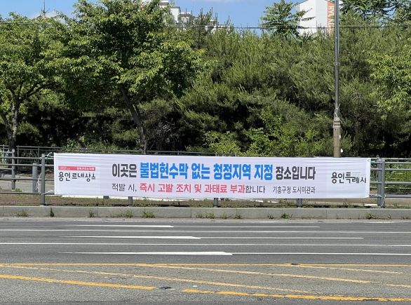 기흥구는 지속적인 단속에도 불구하고 불법 현수막이나 광고물 게시가 끊이지 않는 관내 9개 지역을 ‘불법 현수막 없는 청정지역’으로 지정해 특별 관리에 나섰다.(사진은 이현마을 입구 삼거리에 게시한 경고 현수막