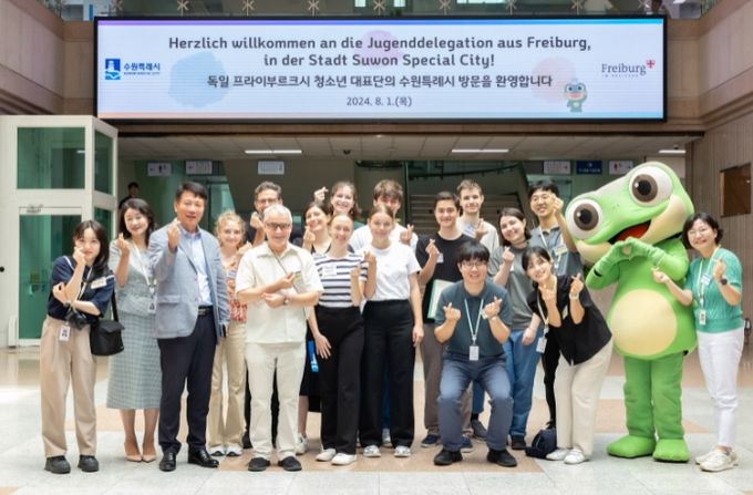 곽도용 수원시 문화청년체육국장과 프라이부르크 청소년 대표단이 함께 시청로비에서 기념사진을 찍고 있다.
