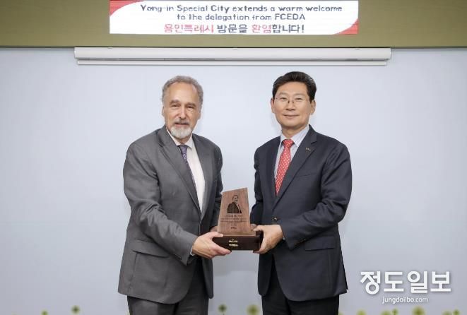 이상일 용인특례시장이 17일 시청 시장실에서 데이비드 켈리 페어팩스카운티 경제개발청 부청장에게 방문기념패를 전달했다.