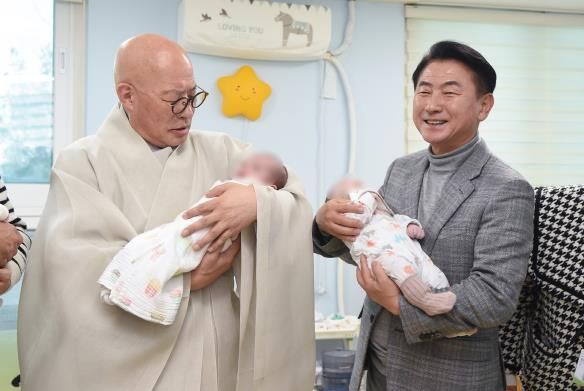 김동근 시장이 12월 10일 대한불교조계종의 자비 나눔 행사에 참석해 총무원장 진우스님과 아기들을 안고 있다.