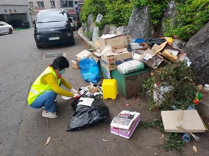 불법투기 감시원이 종량제 봉투를 사용하지 않고 배출한 쓰레기를 단속하고 있다.