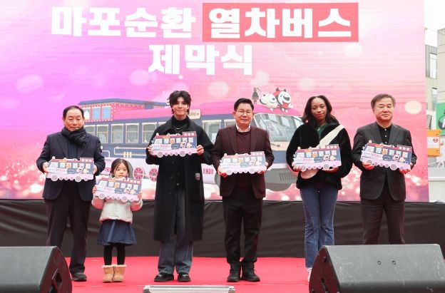 박강수 마포구청장(사진 왼쪽에서 네번째)가 마포순환열차버스 제막식에서 참석자들과 기념촬영을 하고 있다.